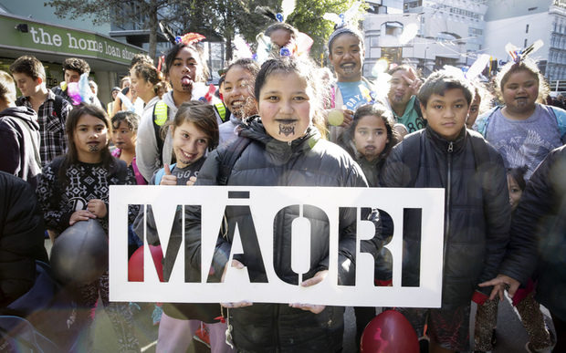 Matariki is a Māori tradition. Māori is on a sign held up proudly by a group of children.