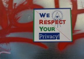Image with red graffiti with sign in front saying we respect your privacy